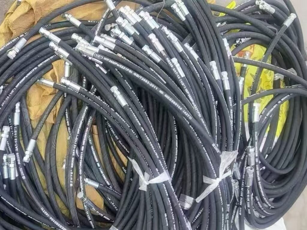 Batch of finished 1/2 inch high-pressure hydraulic hose assemblies (DIN 2SN) with crimped fittings produced by CYT machinery.